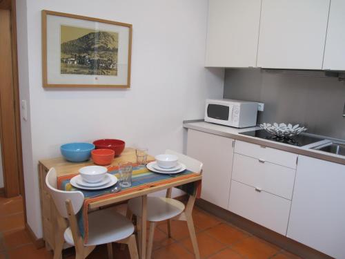 a kitchen with a table with chairs and a microwave at Casa do Cais Cerveira in Vila Nova de Cerveira