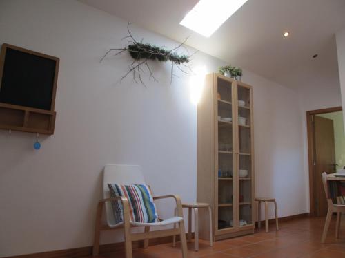 a living room with chairs and a tv and a shelf at Casa do Cais Cerveira in Vila Nova de Cerveira