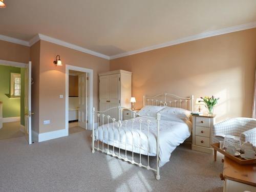a bedroom with a white bed in a room at Dinas Noddfa in Beddgelert
