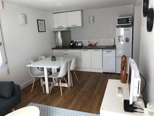a small kitchen with a table and a refrigerator at Gîte la Briantaise in Saint Malo