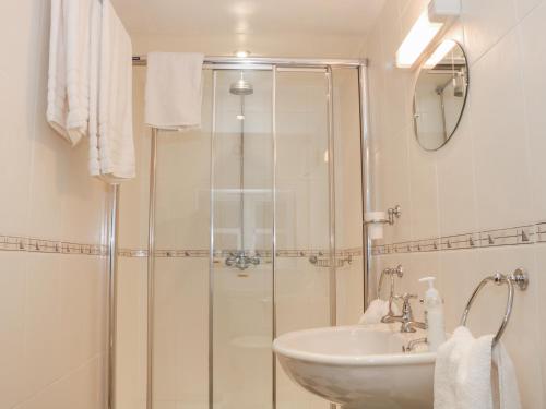 ein Bad mit einer Dusche und einem Waschbecken in der Unterkunft Wash House Cottage in Much Wenlock