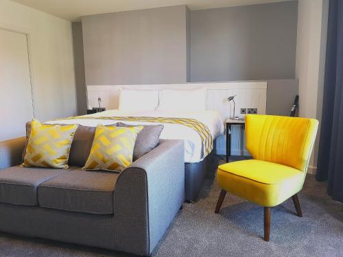 ein Schlafzimmer mit einem Bett, einer Couch und einem Sessel in der Unterkunft Mode Hotel Lytham in Lytham St Annes