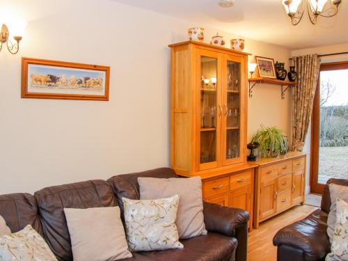 a living room with a couch and a cabinet at Southdown in Much Wenlock