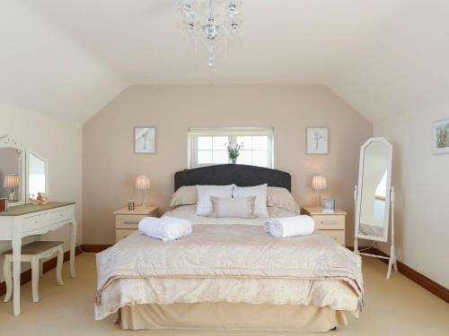 1 dormitorio con 1 cama grande y 2 espejos en Dwyros, en Pwllheli