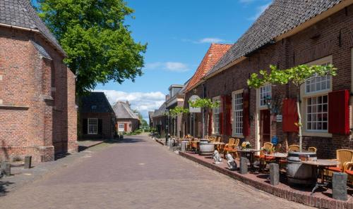 a street in an old town with tables and chairs at Herberg de Gouden Leeuw in Bronkhorst
