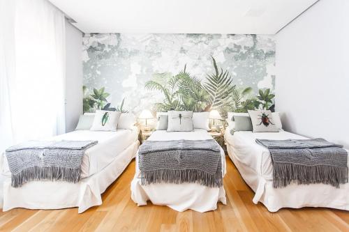 a bedroom with two beds and a wall with plants at Velazquez Manor House in Madrid