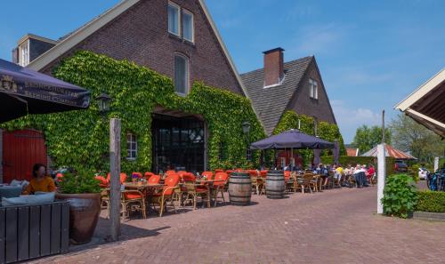 a restaurant with tables and chairs and umbrellas on a street at Herberg de Gouden Leeuw in Bronkhorst