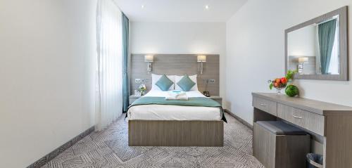 a hotel room with a bed and a mirror at The Lion & Key Hotel in London