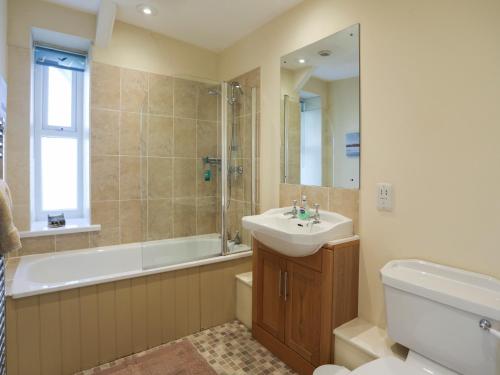 a bathroom with a sink and a tub and a toilet at Dunes - Rhosneigr in Rhosneigr