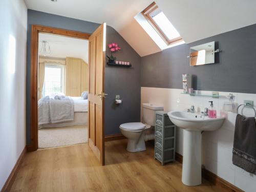 1 dormitorio y baño con lavabo y aseo. en Dwyros, en Pwllheli