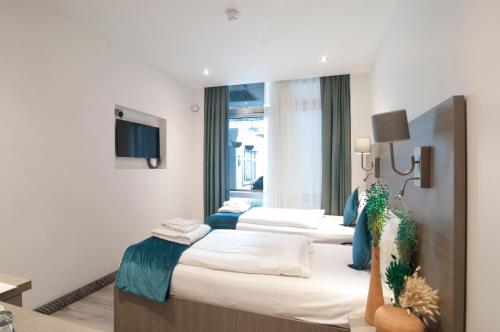 a hotel room with three beds and a tv at The Lion & Key Hotel in London
