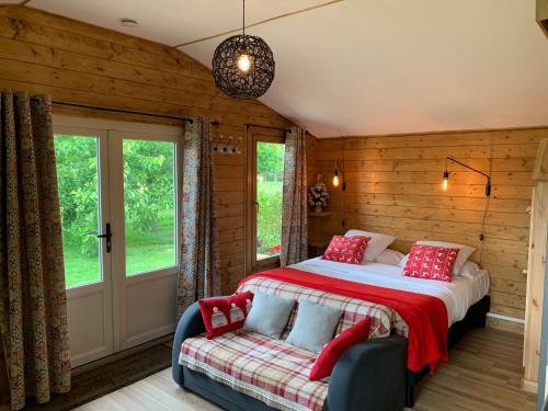 a bedroom with a bed and a couch and a window at La Ferme de Kerraoul in Combrit
