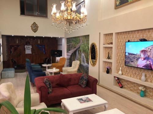 een woonkamer met een bank en een tv aan de muur bij Sanli Hotel Hammam & SPA in Trabzon