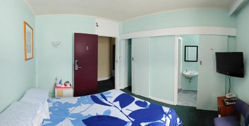 a hotel room with a bed and a sink at Essex Arms in Huntly
