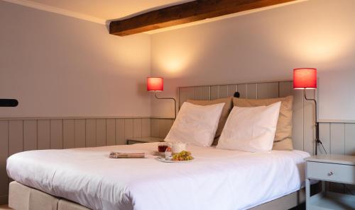 a bedroom with a bed with a plate of food on it at Herberg de Gouden Leeuw in Bronkhorst