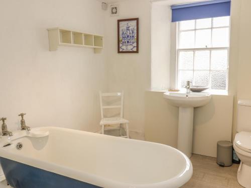 a bathroom with a tub and a sink and a toilet at The Cottage, Polwarth Crofts in Duns