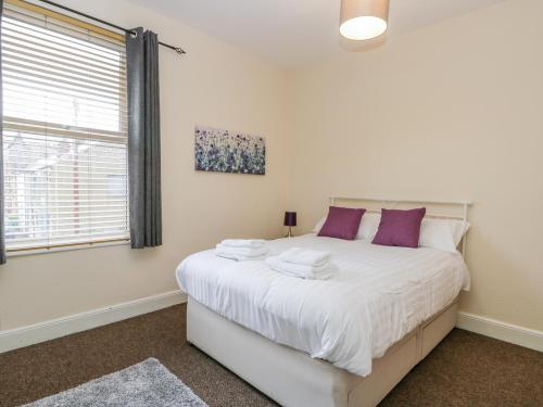 a bedroom with a large white bed with purple pillows at 18 Howard Street in Scarborough