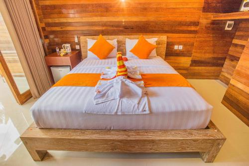 a bedroom with a bed with orange and white sheets at Dinatah Lembongan Villas in Nusa Lembongan