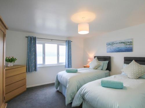 a bedroom with two beds and a window at Glan Dwr Bach in Llandegfan