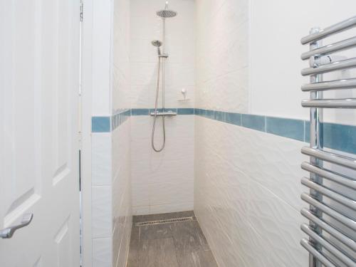 a bathroom with a shower with a glass door at Glan Dwr Bach in Llandegfan