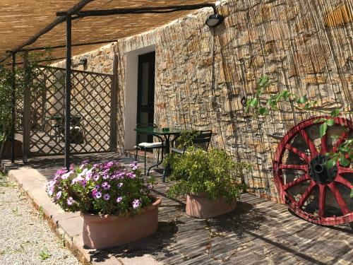 a patio with flowers and a table and a wheel at Agriturismo San Ottaviano in Monterotondo
