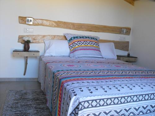 Schlafzimmer mit einem Bett mit einem Kopfteil aus Holz in der Unterkunft A casa do Moinho in Pedrógão Pequeno