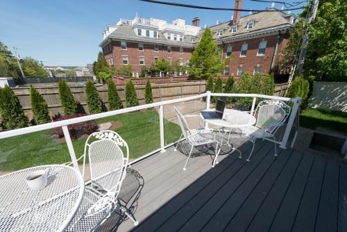 a deck with chairs and tables and a building at The Outlook Inn in Newport
