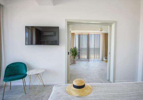 einen Hut auf einem Bett im Wohnzimmer in der Unterkunft Lemon Cliff Luxury B&B in Mamaia Nord – Năvodari