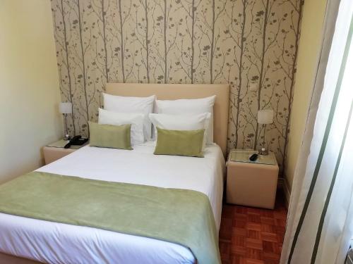 a bedroom with a large white bed with two pillows at Adelaide Hotel in Geres