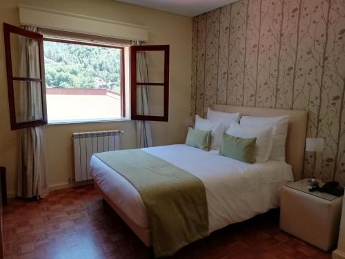 ein Schlafzimmer mit einem großen Bett und einem Fenster in der Unterkunft Adelaide Hotel in Geres