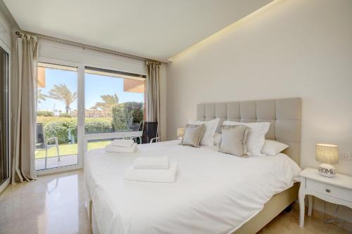 een slaapkamer met een groot wit bed en een groot raam bij Ribera del Marlin in Sotogrande