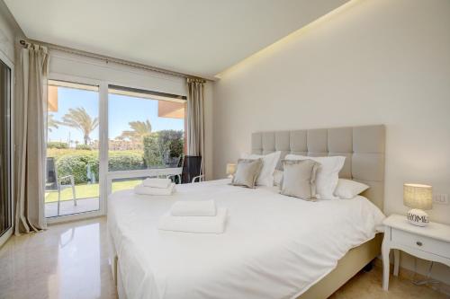 ein Schlafzimmer mit einem großen weißen Bett und einem großen Fenster in der Unterkunft Ribera del Marlin in Sotogrande