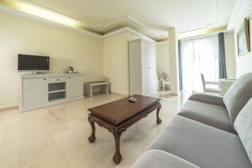 a living room with a couch and a coffee table at Grand Hotel Palladium Santa Eulalia del Río in Santa Eularia des Riu