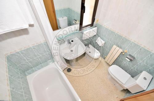 a bathroom with a sink and a toilet and a mirror at Apartamentos Paraíso Centro - BenidormParaíso in Benidorm