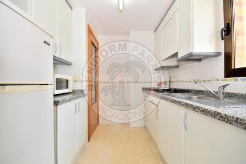 a kitchen with white cabinets and a sink at Apartamentos Paraíso Centro - BenidormParaíso in Benidorm
