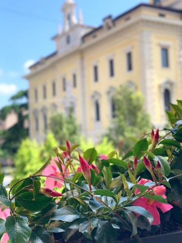 a building in the background with flowers in the foreground at Bue Nero Suites Verona in Verona