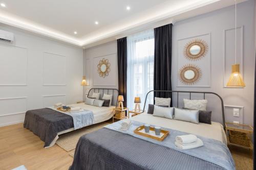 a bedroom with two beds and a room with a mirror at Budapest Holidays Residence in Budapest