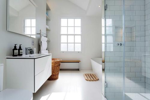 a white bathroom with a shower and a sink at Veeve - Princedale Road Minimalism in London