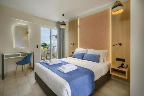 a bedroom with a large bed with a blue blanket at Mare Boutique in Georgioupolis