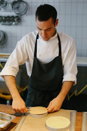 a man in a kitchen preparing a pie at Nira Alpina in Silvaplana