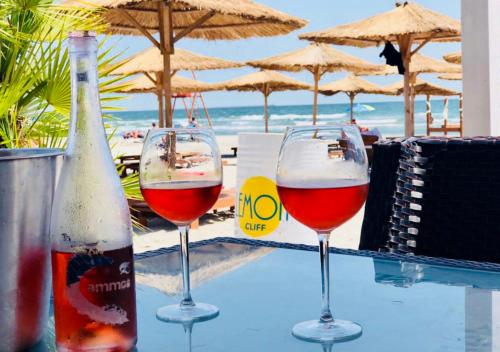 three glasses of wine sitting on a table near the beach at Lemon Cliff Luxury B&B in Mamaia Sat/Năvodari