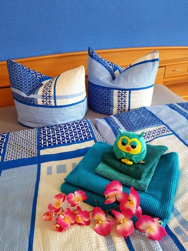 a bed with a green toy on a towel and flowers at Ferienwohnung Hesse in Grimma