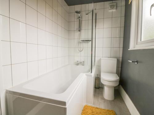 ein weißes Badezimmer mit Badewanne und Toilette in der Unterkunft 2 Hillside Cottages in Ipswich