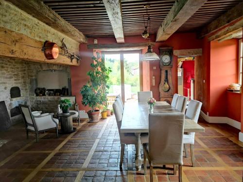 a dining room with a long table and chairs at Le relais des deux tours in Brémondans