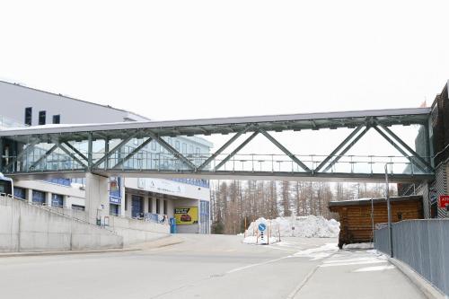 a bridge over a parking lot with a building at Nira Alpina in Silvaplana