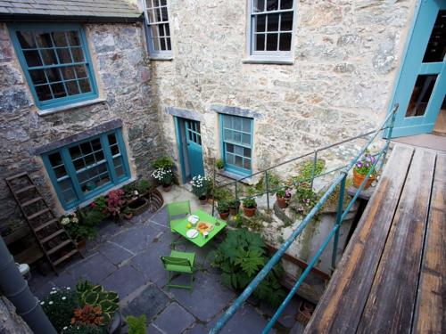 an outdoor patio with a table and a wooden deck at Little Hawthorn in Menai Bridge