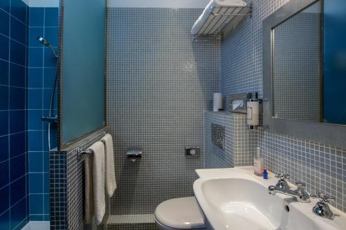 La salle de bains est pourvue d'un lavabo, de toilettes et d'un miroir. dans l'établissement Hotel Louison, à Paris
