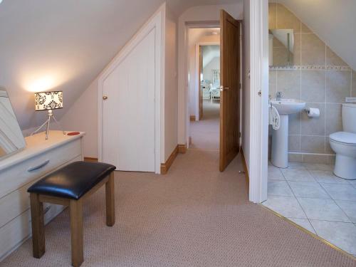 a bathroom with a toilet and a sink and a stool at Hen Stabl Llandwrog in Llandwrog