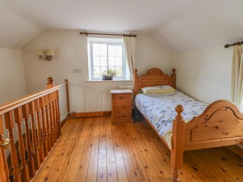 根茲伯勒的住宿－Forge Cottage，一间卧室配有一张床,铺有木地板