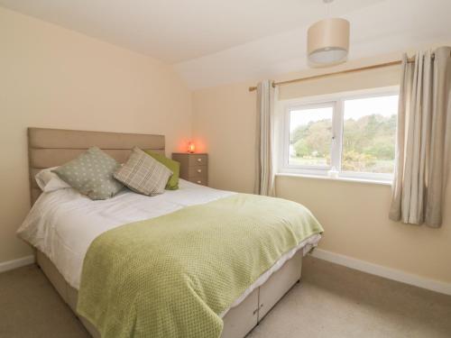 a bedroom with a large bed and a window at 2 Hillside Cottages in Ipswich